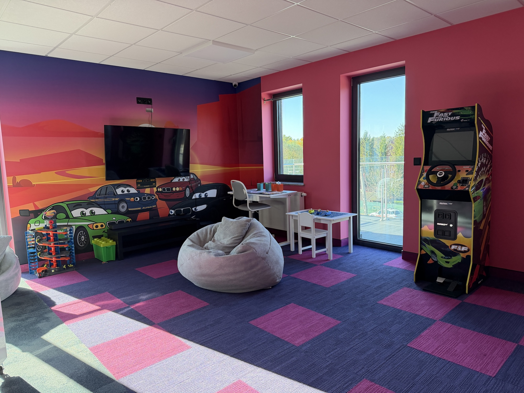 Pokój dziecięcy z telewizorem, biurkiem i automatem arcade w ALPINA GARAGE